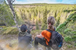Kesäinen kuva patikkaretkeltä. Kuvassa kaksi naista ihastelee metsämaisemaa.